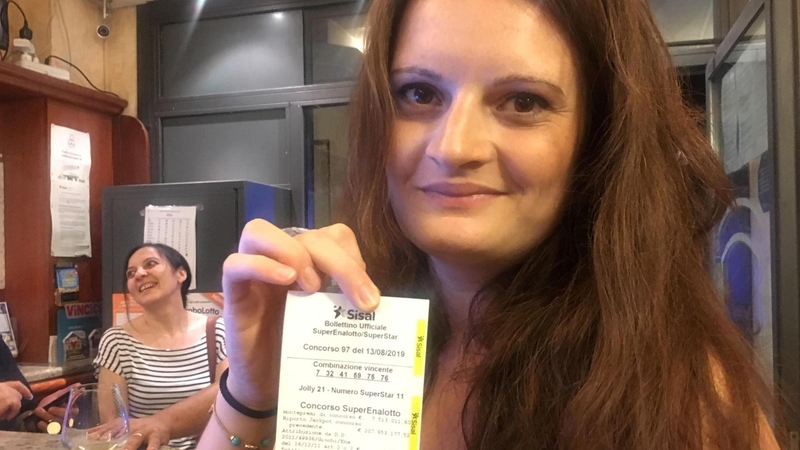The bar's owner Sara Poggi shows the receipt of the winning ticket in the SuperEnalotto lottery