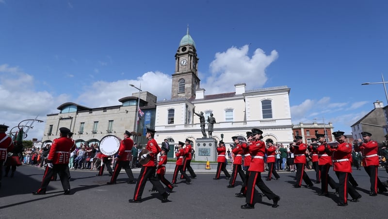 A band marches past the Ulster Defence Force memorial in Lisburn