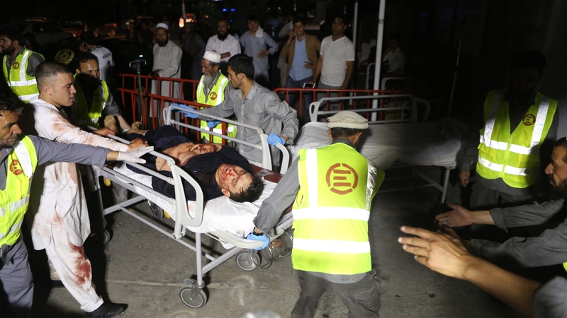 Afghan health workers carry a wounded man into the hospital after the attack