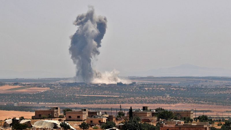 Smoke billows above buildings during a reported air strike by pro-regime forces on Khan Sheikhun yesterday