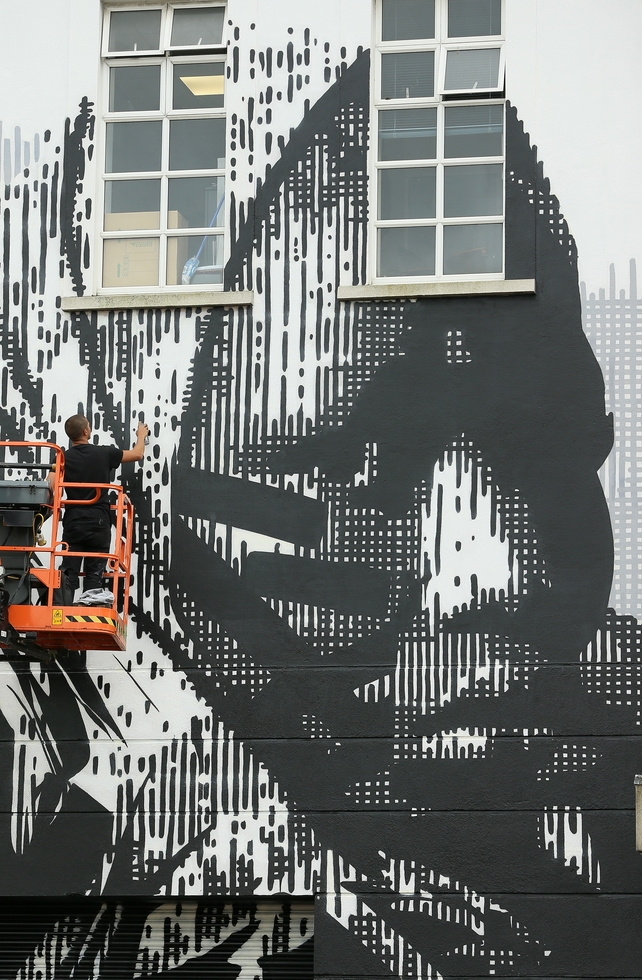 Artist HUARIU uses cherry picker to finish off his mural