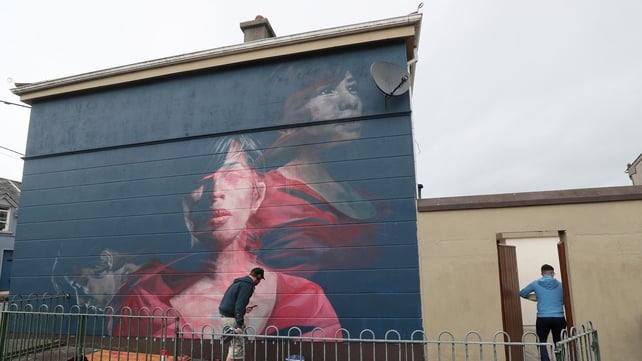 Artist Spear works on a mural titled 'Karelis' for the festival