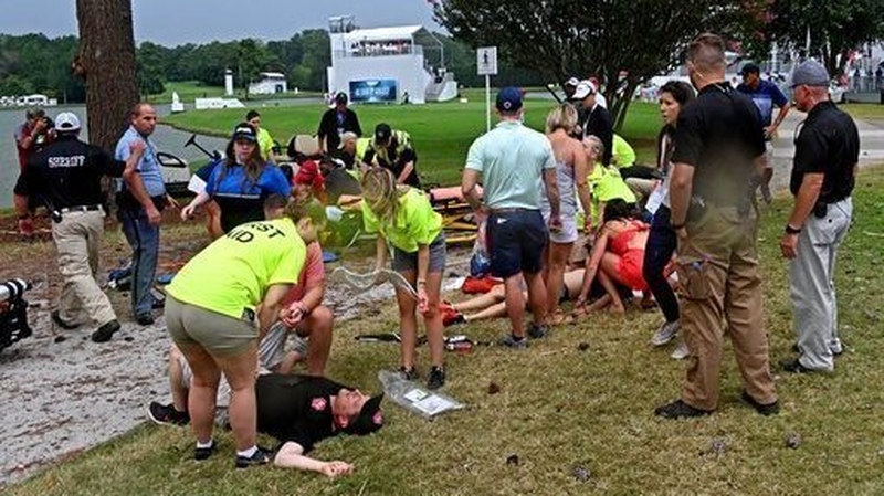 Fans are assisted by medical personnel after a lightning strike