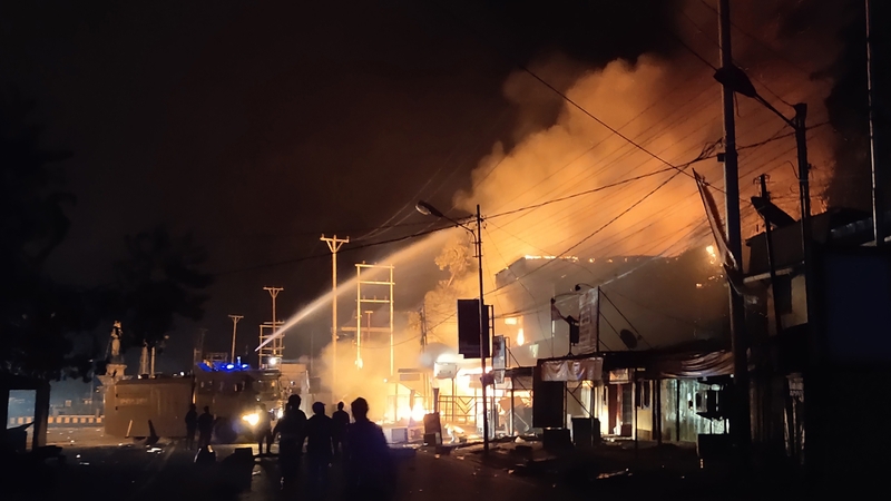 Firefighters battle to put out a burning building that demonstrators set it on fire