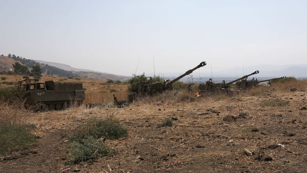 Israeli self-propelled artillery guns are positioned near the Lebanese border