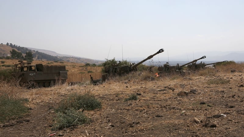 Israeli self-propelled artillery guns are positioned near the Lebanese border