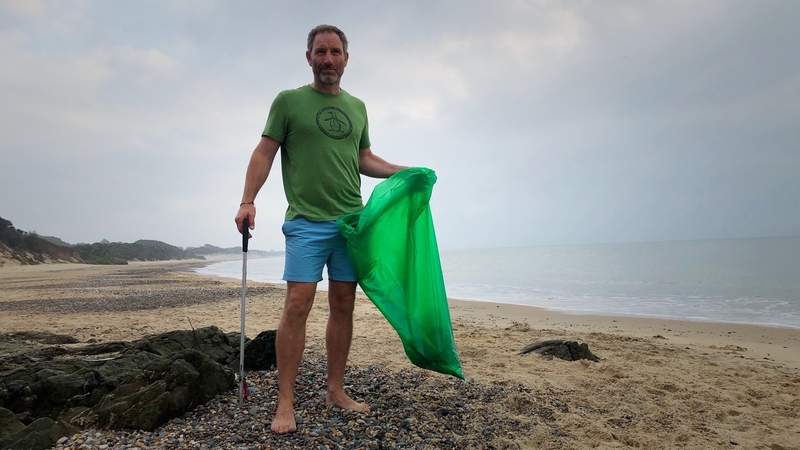 Seán Ferguson collects discarded buckets and spades, along with other rubbish, before his daily swim at sunrise