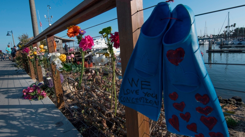 A pair of diving fins and flowers at a memorial wall near the Truth Aquatics moorings in Santa Barbara