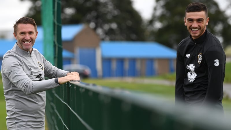 Republic of Ireland assistant coach Robbie Keane (l) gives Troy Parrott a few words of wisdom.