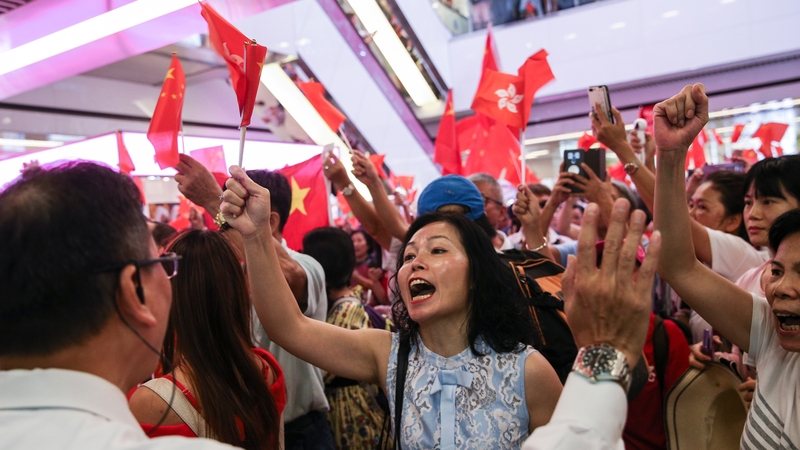 Pro-China supporters waving Chinese flags shout slogans against anti-government protesters