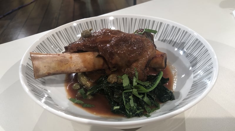 Lamb shanks with aubergine and kale.