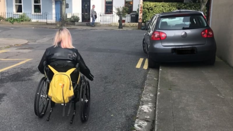 Saoirse Smith points out a spot where cars regularly block the pavement on her street