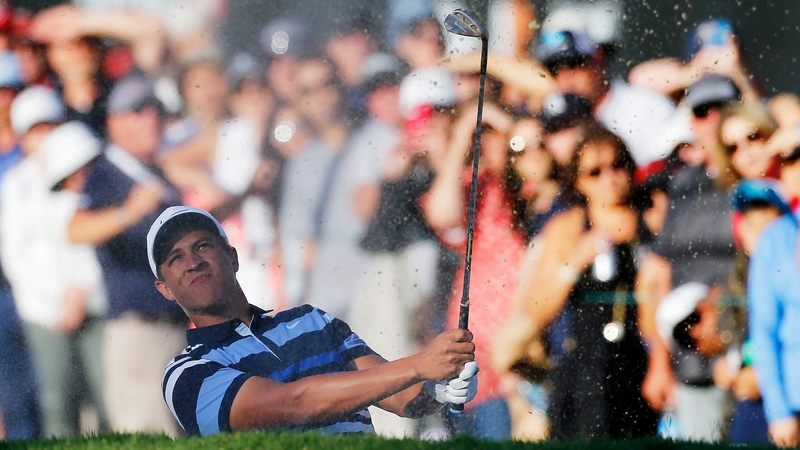 Cameron Champ hits out of a bunker on the 18th hole