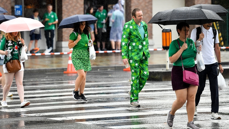 Supporters make their way to the game in rainy Kobe