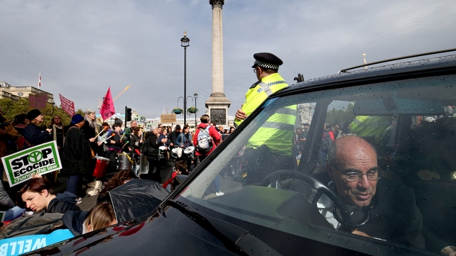 An Extinction Rebellion protester locks himself to the steering wheel of a hearse at the roundabout in Trafalgar Square, in Westminster, London