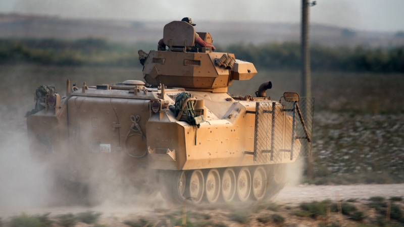 A Turkish armoured vehicle drives down a road during a military operation in Kurdish areas of northern Syria