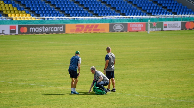 Joe Schmidt, left, IRFU head of operations Ger Carmody and scrum coach Greg Feek examine the playing surface at Hakatanomori Stadium