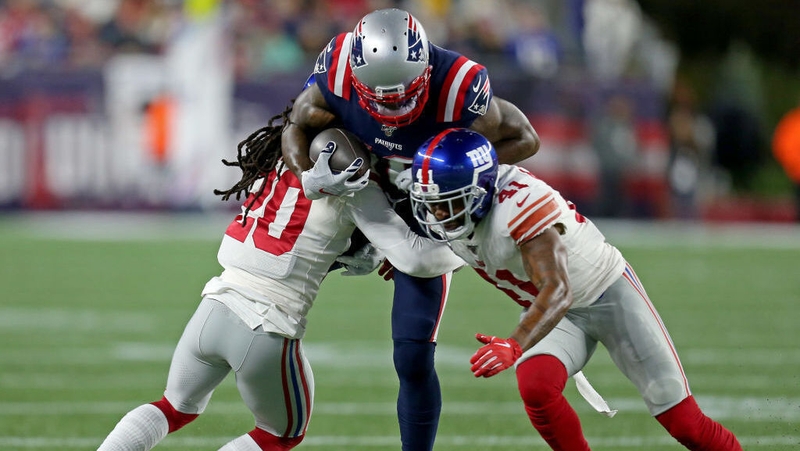 Josh Gordon of the New England Patriots is hit by Janoris Jenkins, left, of the New York Giants and Antoine Bethea