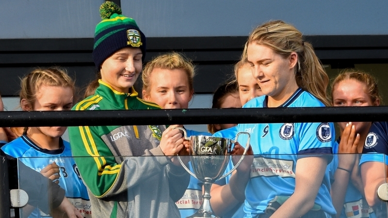Simonstown captain Ailbhe McHugh receives the county title from Meath U-16 player Aoife Hughes, who is currently battling cancer.