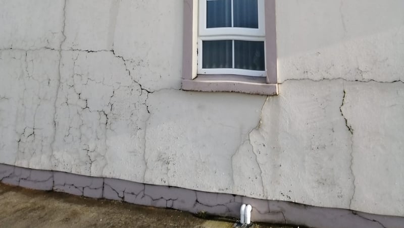 Tá cúpla míle teach cónaithe i nDún na nGall a tógadh le brící ina bhfuil an t-ábhar míoca