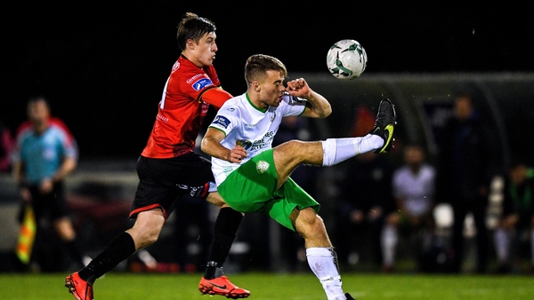 Villius Labutis of Cabinteely in action against Jake Hyland