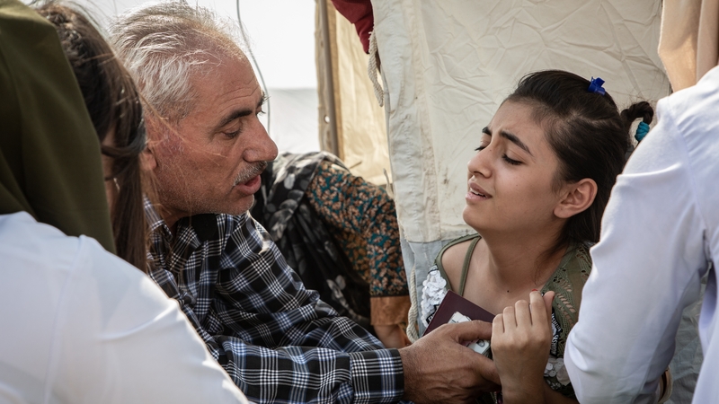 A young girl and her father receiving healthcare in Bardarash camp