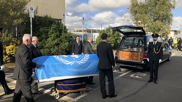 Members of Mr Ryan's family were present as his coffin, draped in the UN flag, was brought out of Dublin Airport