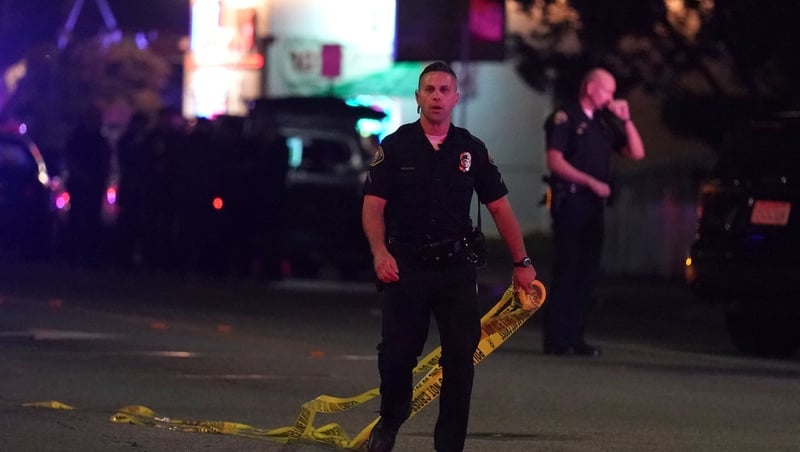 Police close off the scene of a shooting that left three people dead