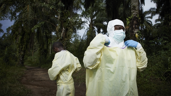 Health workers don protective equipment before a funeral in the North Kivu province, Democratic Republic of the Congo, in August
