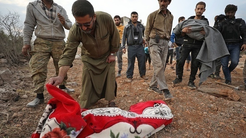 A man identifies the body of a child found in the rubble of a building destroyed by a reported Russian airstrike