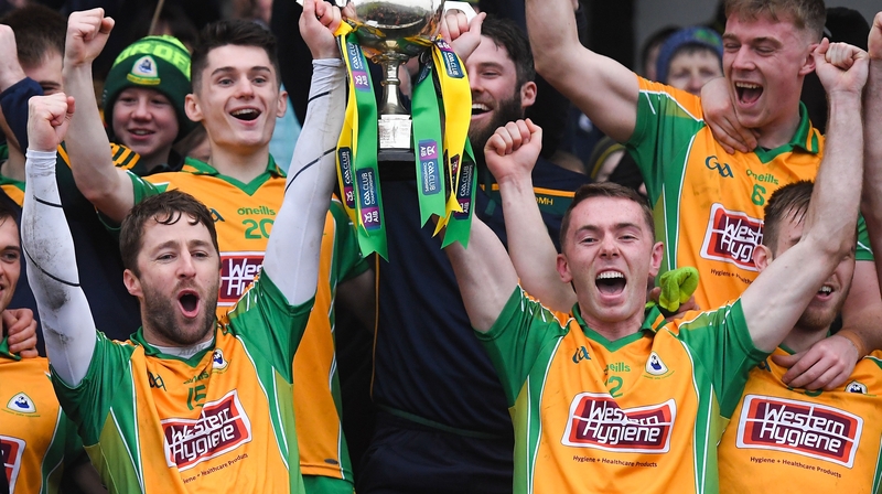 Corofin captain Micheál Lundy and Jason Leonard lift the Shane McGettigan Cup