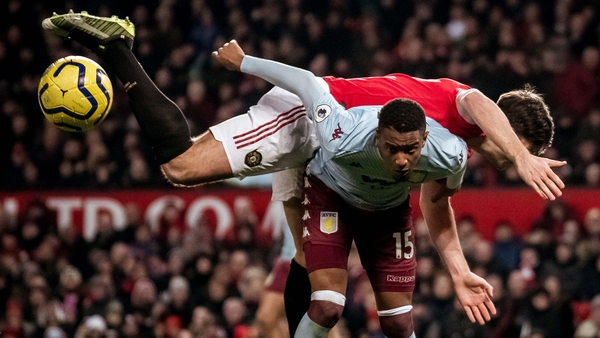 Harry Maguire battles for possession against Aston Villa