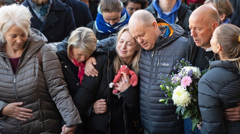 Leanne O'Brien, girlfriend of Jack Merritt, is comforted by family members during a vigil at the Guildhall in Cambridge