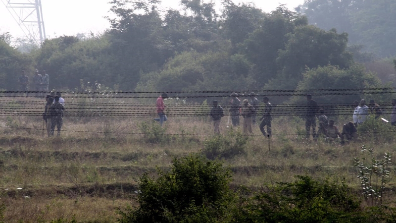 Police officers investigate the area where all four men accused in the rape and murder were killed