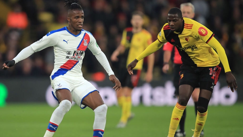 Wilfriend Zaha is challenged by Abdoulaye Doucoure