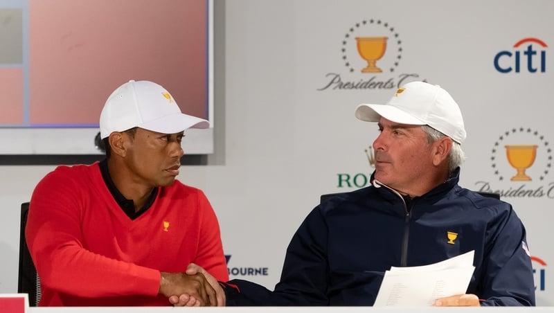 Playing Captain Tiger Woods of the United States team shakes hands with his assistant captain Fred Couples