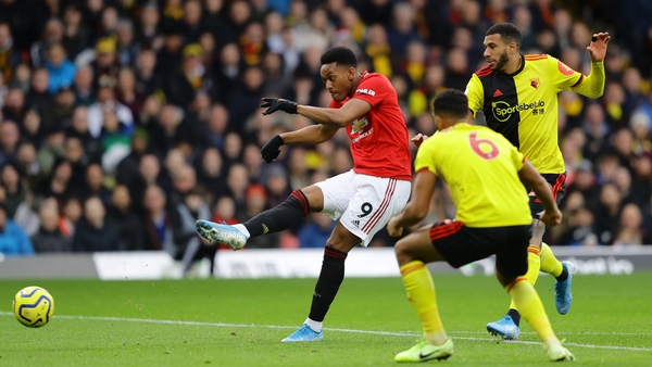 Anthony Martial of Manchester United shoots wide under pressure from Troy Deeney and Etienne Capoue