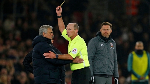 Southampton manager Ralph Hasenhuttl (R) looks on as referee Mike Dean shows Jose Mourinho (L) a yellow card