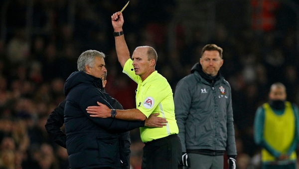 Southampton manager Ralph Hasenhuttl (R) looks on as referee Mike Dean shows Jose Mourinho (L) a yellow card