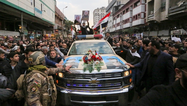 Mourners surround a car carrying the coffin of Iranian military commander Qasem Soleimani