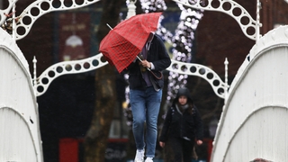 A man battles wind and rain while crossing the Ha'penny Bridge in Dublin (Photos: Rolling News)