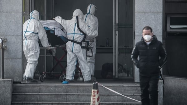 Medical staff carry a patient into the Jinyintan hospital in Wuhan