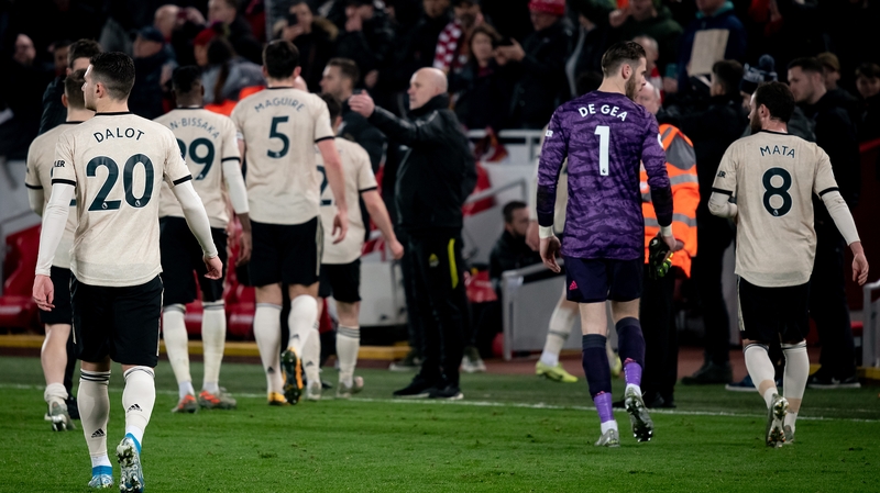 Manchester United team leave the Anfield pitch