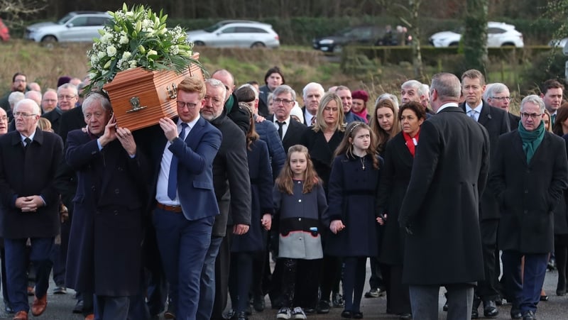 The coffin is carried into St James' Church