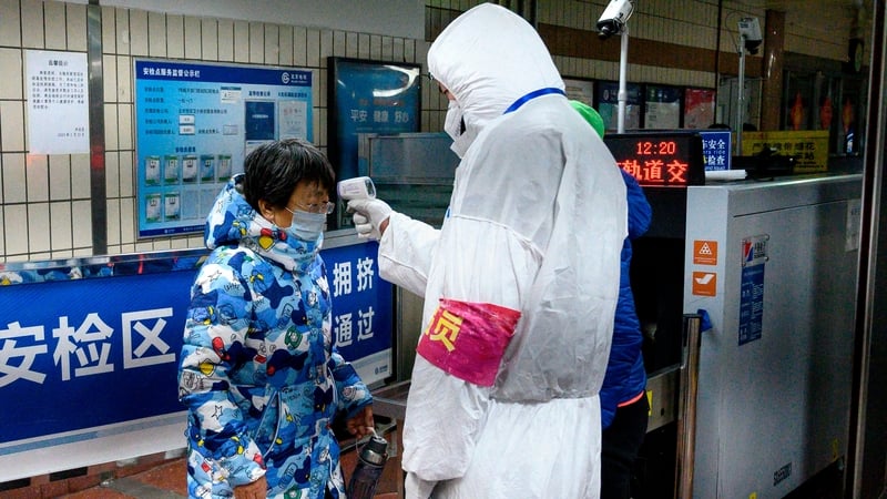 A passenger's temperature is checked at the entrance of subway station in Beijing