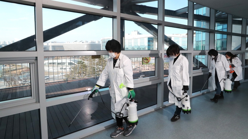 Quarantine officials spray disinfectant in a hallway at a government complex in South Korea