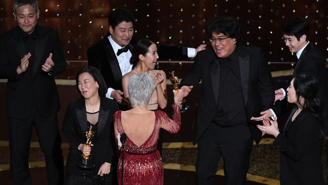 Parasite producers Kwak Sin-ae (L) and Bong Joon-ho (R) accept the award for Best Picture for Parasite