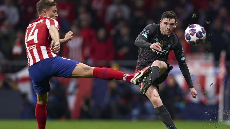 Marcos Llorente (L) tries to block Liverpool's Andy Robertson