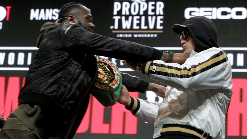 Deontay Wilder (L) and Tyson Fury get to grips with each other