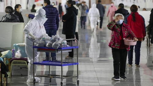 A nurse distributes medicine to patients at a temporary hospital situated in the Tazihu Gymnasium in Wuhan, China